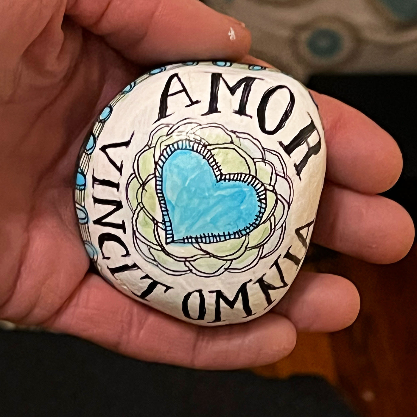 Hand painted stone - "Love Conquers All"