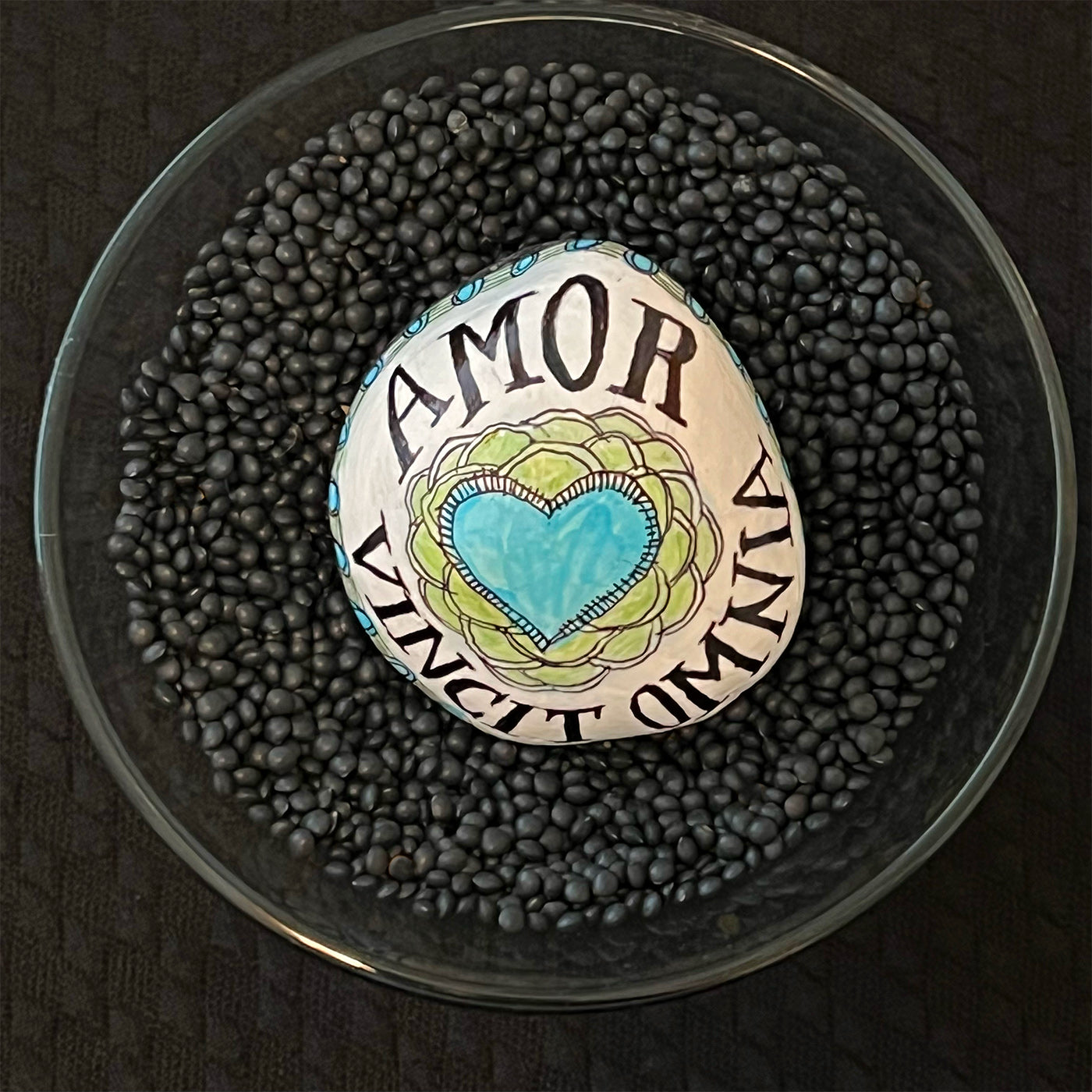 Hand painted stone - "Love Conquers All"